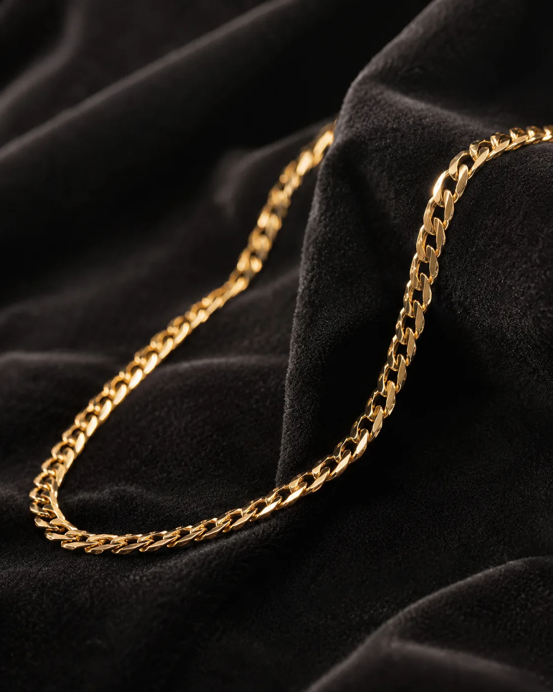 Gold curb chain necklace on dark velvet