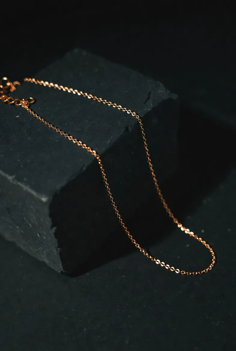Studio macro of a fine gold necklace on a dark surface